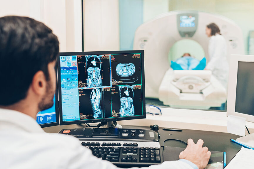 A Patient Receives a MRI Scan While a Radiologist and Nurse Look After Their Care
