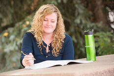 A female student studying outdoors at a picnic table