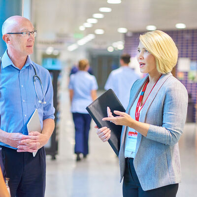 A hospital administrator converses with a doctor and nurse