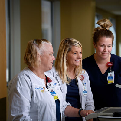 A nursing director and two employees viewing a monitor