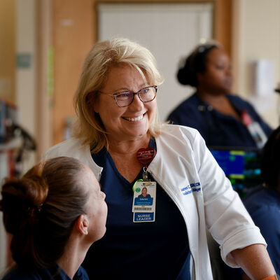 A nurse leader conversing with her employees
