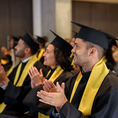 Graduates applauding during a graduation ceremeny