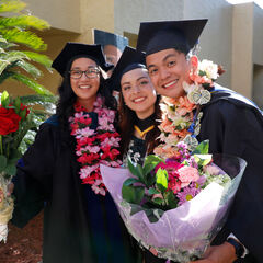 A group of graduates posing for a photo outdoors