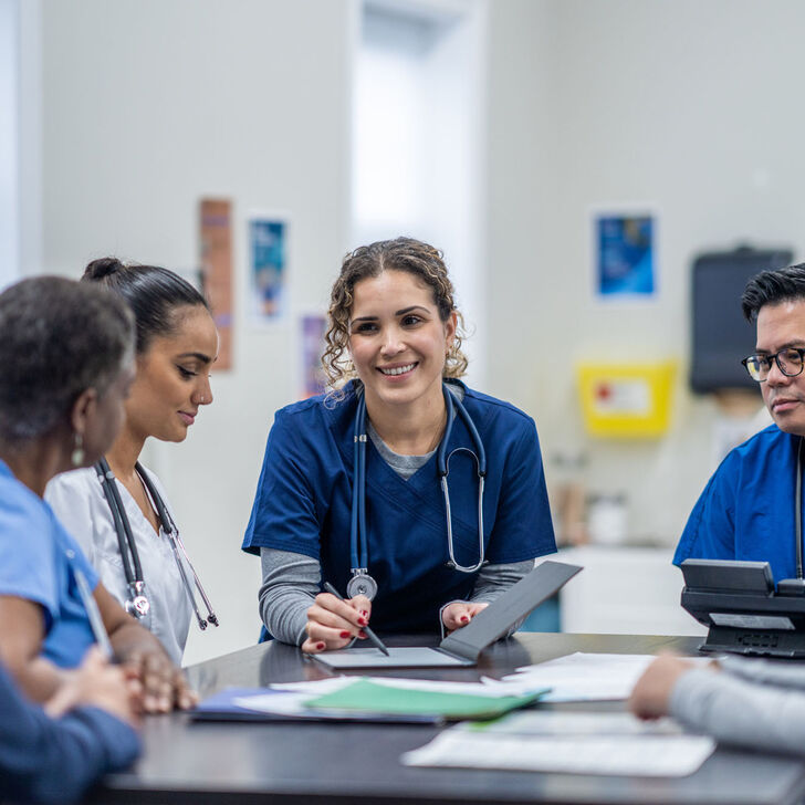 A female nurse supervisor meets with her team